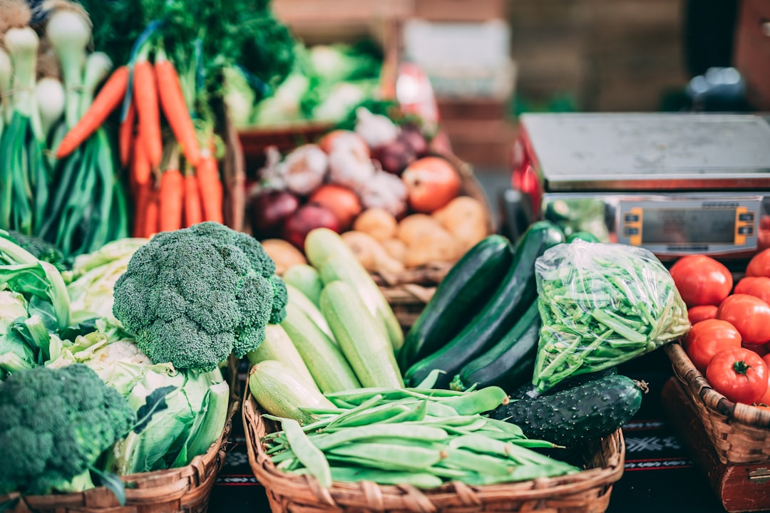 Person holding a tablet with vegetables in background